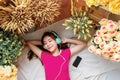 Happy Young Woman Laying on the Floor to Listening Music via Smart Phone, Closed Eyes and Smiling. Girl relaxing in Cozy Place, S