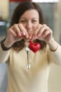 Happy young woman with leather red heart key trinket as a valentines day gift close up photo Royalty Free Stock Photo