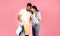 Happy young woman looking inside paper bag, shopping with boyfriend Royalty Free Stock Photo