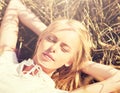 Happy young woman lying on cereal field or hay Royalty Free Stock Photo