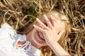 Happy young woman lying on cereal field