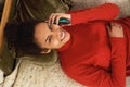 Happy young woman lying on couch and talking on cellphone Royalty Free Stock Photo