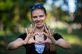 Young woman makes hands in shape of love heart