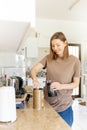 Happy young woman making coffee in kitchen - french press coffee. Caucasian female model in her twenties at home Royalty Free Stock Photo