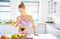 Happy young woman making fresh fruit juice Royalty Free Stock Photo