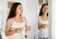 Happy young woman measuring breasts with measuring tape Royalty Free Stock Photo