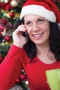 Happy young woman near Christmas tree making phone call Royalty Free Stock Photo