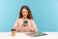 Happy young woman, office employee, taking break at workplace with closed laptop and coffee, reading message Royalty Free Stock Photo