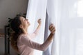 Happy young woman open curtains welcome new day Royalty Free Stock Photo