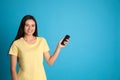 Happy young woman operating air conditioner with remote control on light blue background. Space for Royalty Free Stock Photo