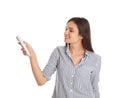 Happy young woman operating air conditioner with remote control on white Royalty Free Stock Photo