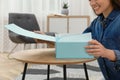 Happy young woman with parcel at home, closeup. Internet shopping