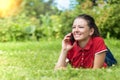 Happy young woman in the park smiling and talking on smartphone. beautiful girl get a good news on her mobile phone. leisure in na Royalty Free Stock Photo