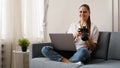 Happy young woman with photo camera using laptop at home Royalty Free Stock Photo