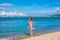 Happy young woman in pink swimsuit jumping on the tropical beach Royalty Free Stock Photo