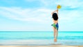 Happy young woman in pink swimwear hand holding hat and jumping at sand beach. Relaxing and enjoying holiday at tropical paradise Royalty Free Stock Photo