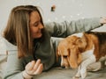 Happy young woman playing with her dog on a white background. Beagle dog with owner. Girl and dog at home