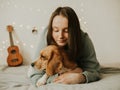 Happy young woman playing with her dog on a white background. Beagle dog with owner. Girl and dog at home