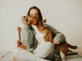 Happy young woman playing with her dog on a white background. Beagle dog with owner. Girl and dog at home