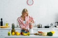 Young woman preparing tasty nutritious smoothie in blender