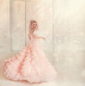 Happy young woman princess dancing in lush vintage pink dress. white royal room. Queen blond hair, golden crown.