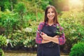 Happy young woman pruning plants in a nursery