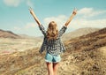 Happy young woman raises hands up on a hiking trail on top of the mountain, view from the back, Tenerife, Canary Islands Royalty Free Stock Photo