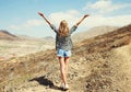 Happy young woman raises hands up on a hiking trail on top of the mountain, view from the back, Tenerife, Canary Islands Royalty Free Stock Photo