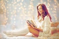 Happy young woman reading book in bed at home Royalty Free Stock Photo