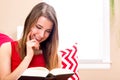 Happy young woman reading a book on her couch Royalty Free Stock Photo