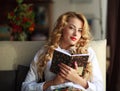 Happy young woman reading book at home Royalty Free Stock Photo