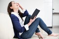 Happy young woman reading book at home Royalty Free Stock Photo