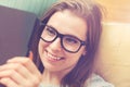 Happy young woman reading an e-book on her couch Royalty Free Stock Photo