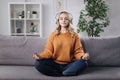 Woman meditating in headphones on couch Royalty Free Stock Photo