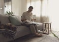 Woman relaxing on the sofa and watching pictures in the photo album