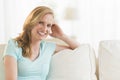 Happy Young Woman Relaxing On Sofa