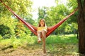 Happy young woman resting in comfortable hammock at garden Royalty Free Stock Photo