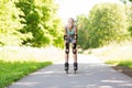 Happy young woman in rollerblades riding outdoors