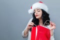 Happy young woman with santa hat holding a shopping bag Royalty Free Stock Photo