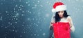 Happy young woman with santa hat holding a shopping bag Royalty Free Stock Photo