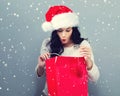 Happy young woman with santa hat holding a shopping bag Royalty Free Stock Photo