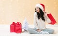 Happy young woman with santa hat holding a shopping bag Royalty Free Stock Photo