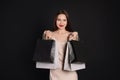 Happy young woman with shopping bags on black background. Big sale Royalty Free Stock Photo