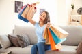 Happy young woman with shopping bags and credit card at home Royalty Free Stock Photo