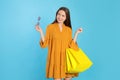 Happy young woman with shopping bags on light blue background. Big sale Royalty Free Stock Photo