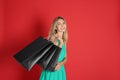 Happy young woman with shopping bags on red background, space for text. Black Friday Sale Royalty Free Stock Photo