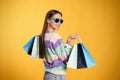 Happy young woman with shopping bags on yellow background. Big sale Royalty Free Stock Photo
