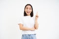 Happy young woman showing advertisement, pointing up, eureka moment, girl has revelation, got an idea, white background Royalty Free Stock Photo