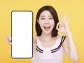Happy Young woman  showing blank screen Smart phone and ok gesture Royalty Free Stock Photo