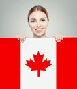 Happy young woman showing the Canada flag background. Live, work